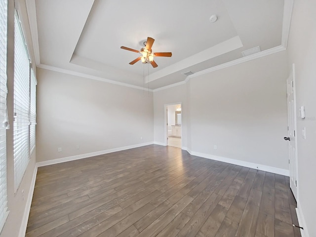 empty room featuring a tray ceiling, ceiling fan, and dark hardwood / wood-style floors