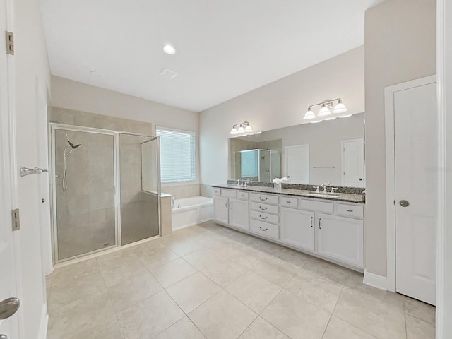 bathroom featuring plus walk in shower, vanity, and tile patterned flooring