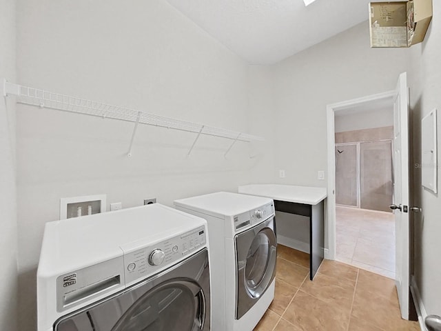 clothes washing area featuring washing machine and clothes dryer and light tile patterned floors