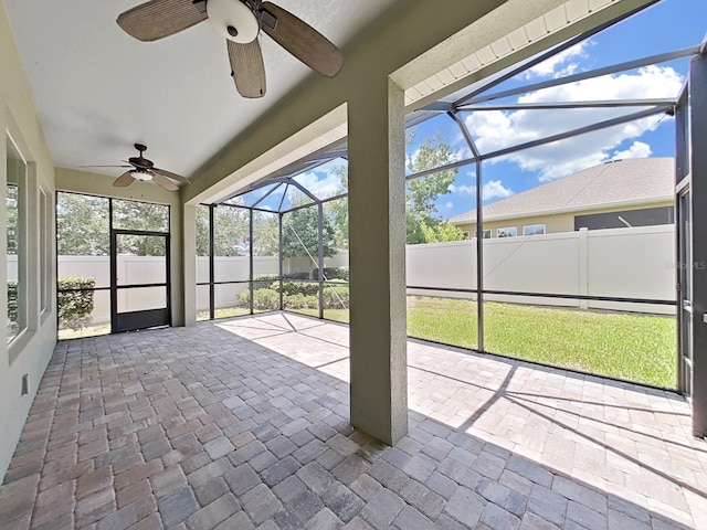 unfurnished sunroom with ceiling fan