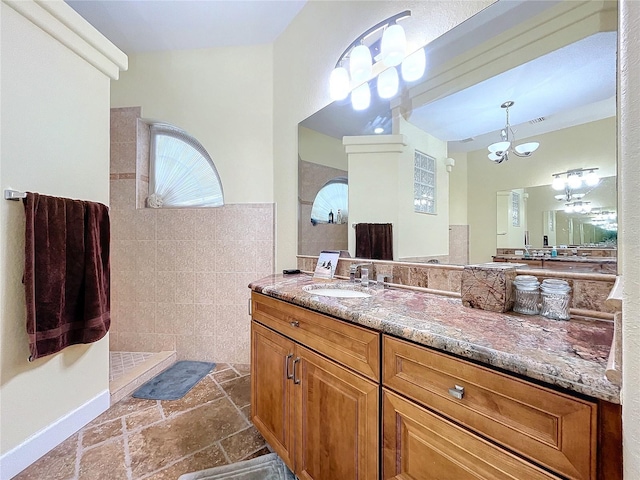 bathroom featuring vanity, a shower, and a notable chandelier