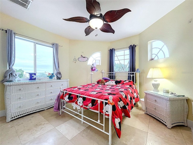 tiled bedroom featuring ceiling fan