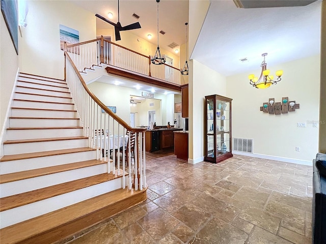 stairs with an inviting chandelier and a high ceiling