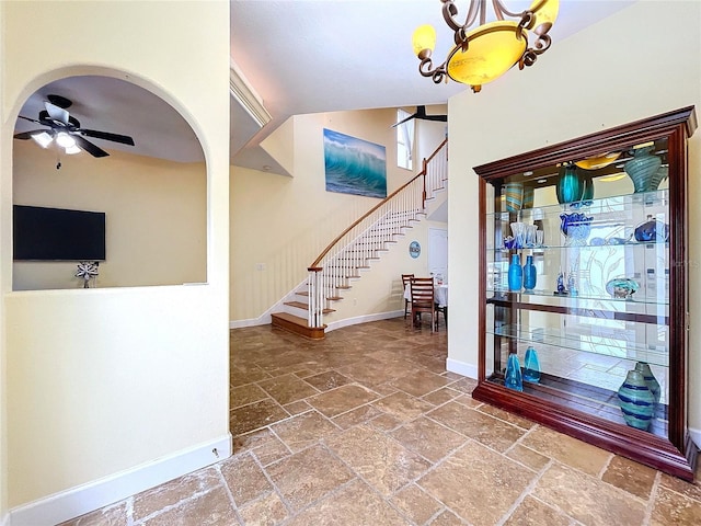 foyer featuring ceiling fan with notable chandelier