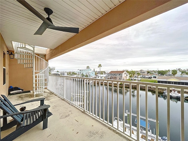 balcony featuring a water view and ceiling fan