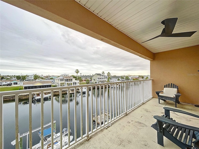 balcony featuring ceiling fan and a water view