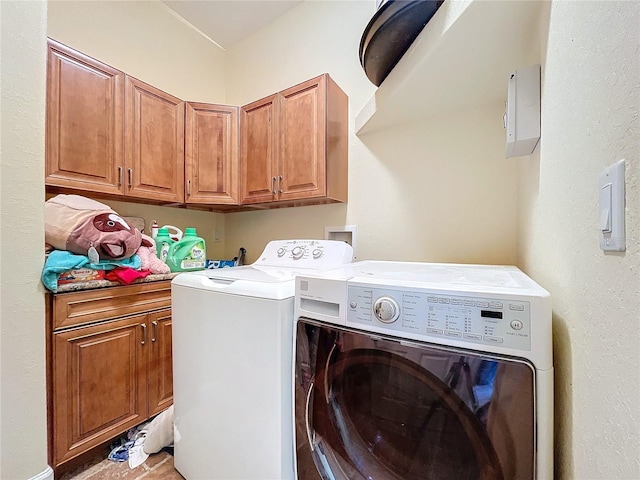 washroom featuring cabinets, washing machine and dryer, and light tile patterned flooring