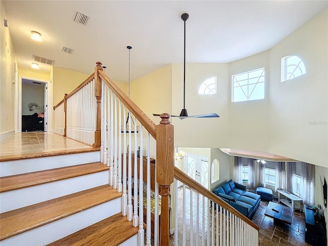 stairway featuring ceiling fan