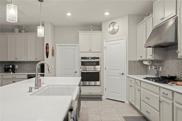 kitchen with white cabinets, appliances with stainless steel finishes, light tile patterned floors, and hanging light fixtures