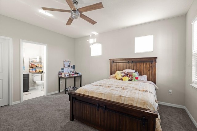 carpeted bedroom with ensuite bathroom and ceiling fan