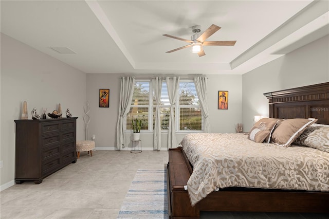 bedroom with a tray ceiling and ceiling fan