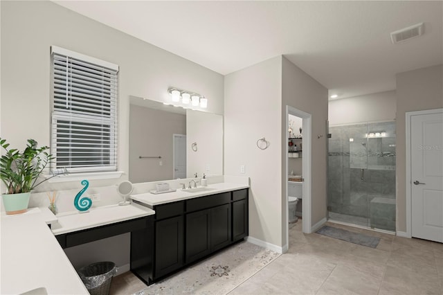 bathroom with tile patterned flooring, vanity, toilet, and walk in shower