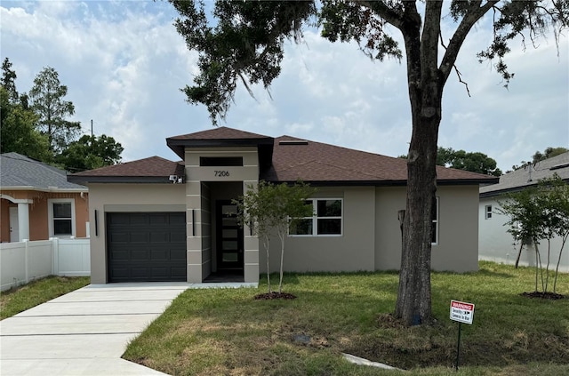 view of front of property with a garage and a front lawn