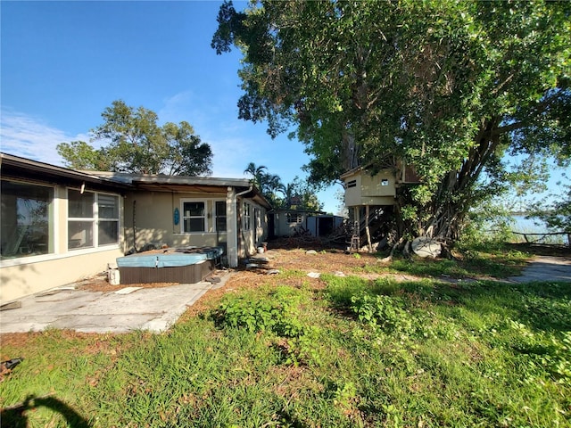 view of yard featuring a hot tub and a patio area