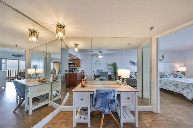 kitchen with dark hardwood / wood-style floors, a kitchen island, butcher block countertops, a breakfast bar area, and ceiling fan