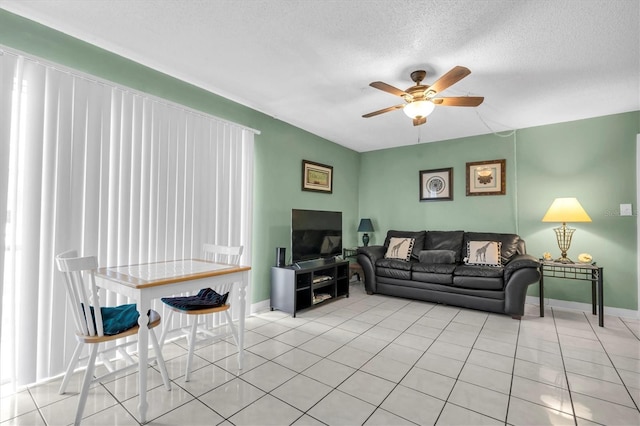 living room with a textured ceiling, ceiling fan, and light tile patterned flooring