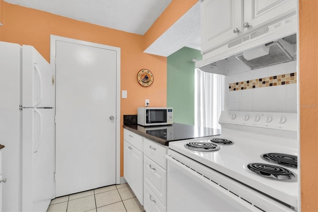 kitchen with white cabinets, white appliances, a textured ceiling, and light tile patterned floors