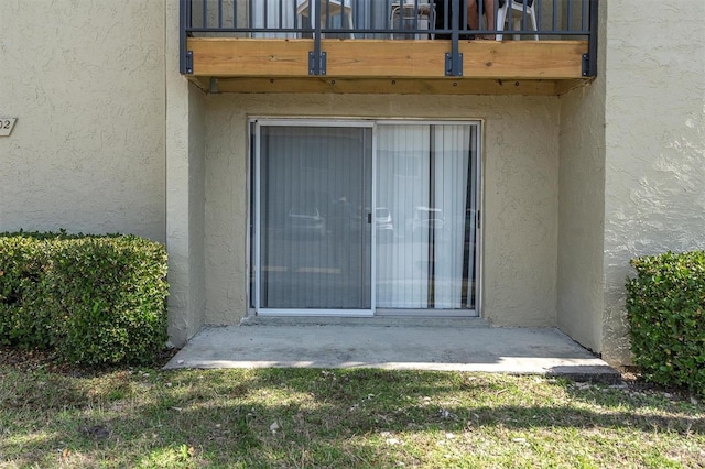 view of exterior entry with a balcony