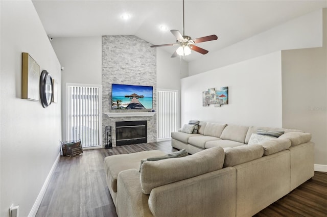 living room with ceiling fan, dark wood-type flooring, vaulted ceiling, and a fireplace