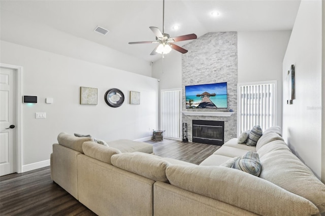 living room featuring a fireplace, ceiling fan, vaulted ceiling, and dark wood-type flooring