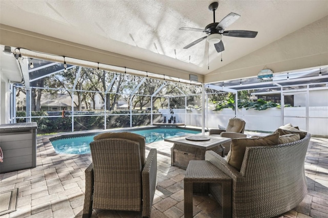 view of swimming pool with ceiling fan, a patio area, and glass enclosure