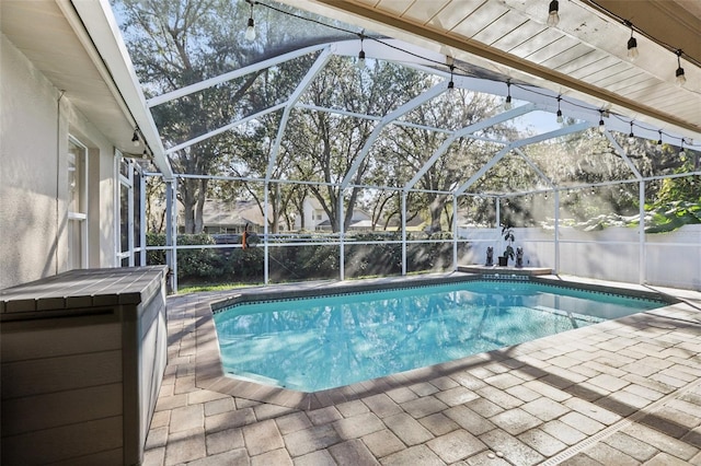 view of swimming pool with a lanai and a patio