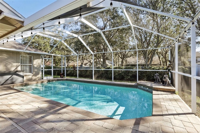 view of swimming pool featuring a patio area and glass enclosure