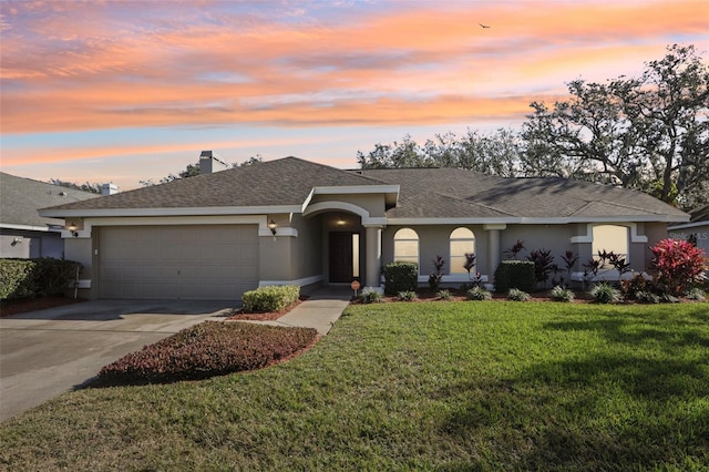 single story home featuring a garage and a yard