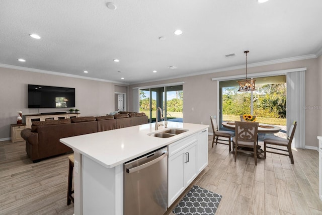 kitchen featuring sink, decorative light fixtures, a center island with sink, dishwasher, and white cabinets