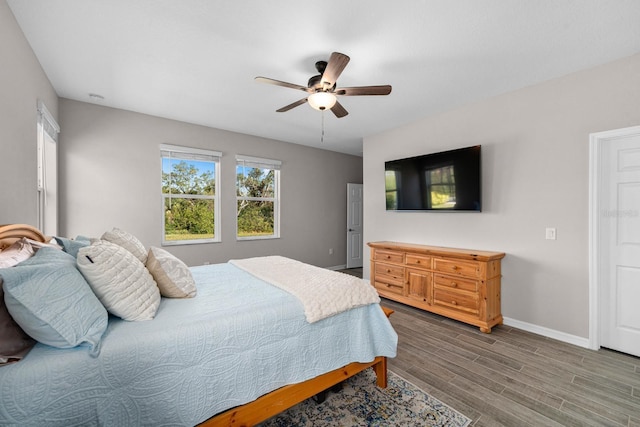 bedroom with ceiling fan, hardwood / wood-style floors, and multiple windows