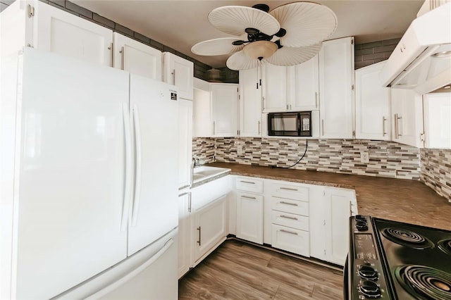 2005 E Crenshaw St, Tampa, FL 33610 - kitchen featuring hardwood / wood-style flooring, extractor fan, black appliances, white cabinetry, and ceiling fan