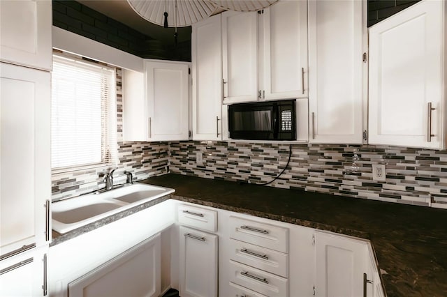 2005 E Crenshaw St, Tampa, FL 33610 - kitchen with sink, white cabinets, and dark stone counters