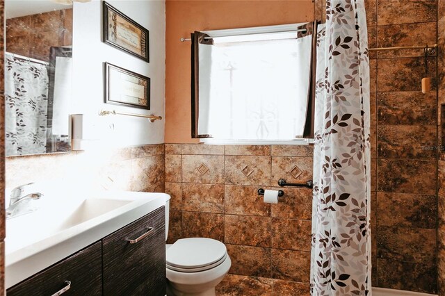 2005 E Crenshaw St, Tampa, FL 33610 - bathroom with tile walls, toilet, curtained shower, and vanity