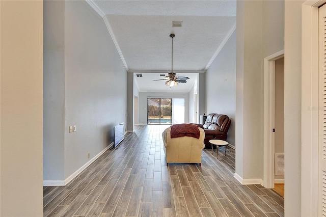 interior space featuring a textured ceiling, ceiling fan, and crown molding