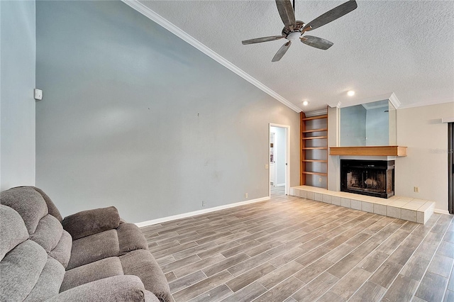 living room with lofted ceiling, a textured ceiling, ceiling fan, and crown molding