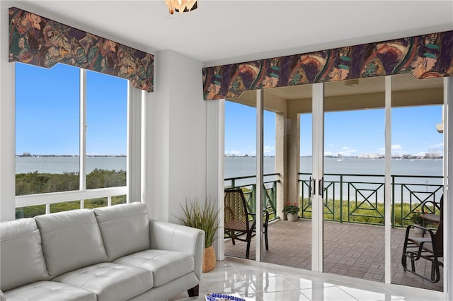 sunroom featuring a water view