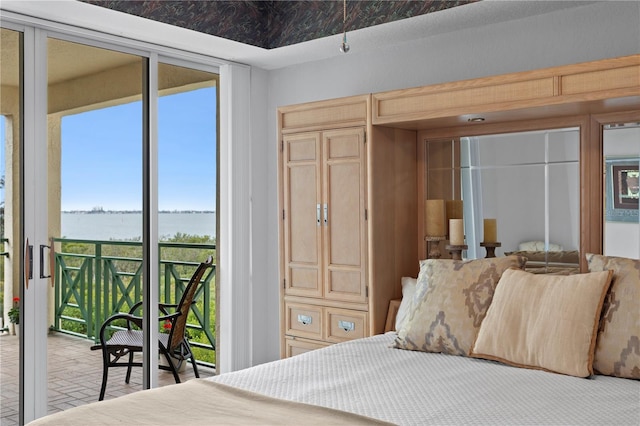 bedroom with access to outside and a water view