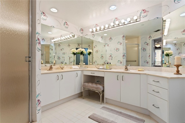 bathroom featuring a shower with shower door, tile patterned floors, and vanity