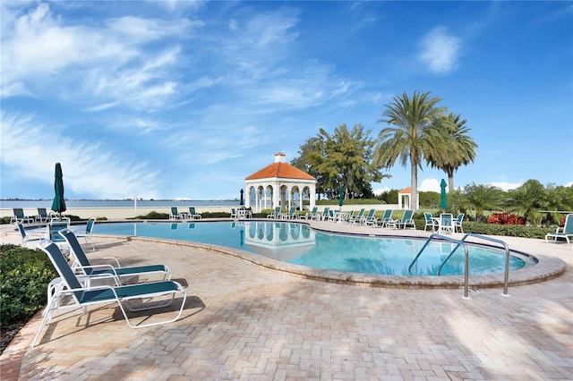 view of swimming pool with a water view and a gazebo