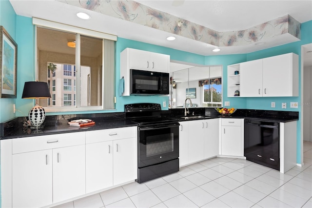 kitchen featuring black appliances, light tile patterned floors, sink, and white cabinetry