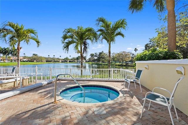 view of swimming pool featuring a water view, an in ground hot tub, and a patio