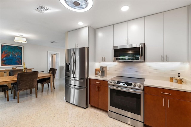 kitchen featuring white cabinetry, appliances with stainless steel finishes, and tasteful backsplash