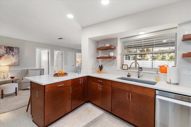 kitchen featuring stainless steel dishwasher, kitchen peninsula, and sink