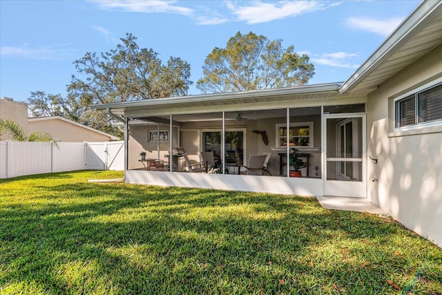 rear view of house with a sunroom, a yard, and a patio