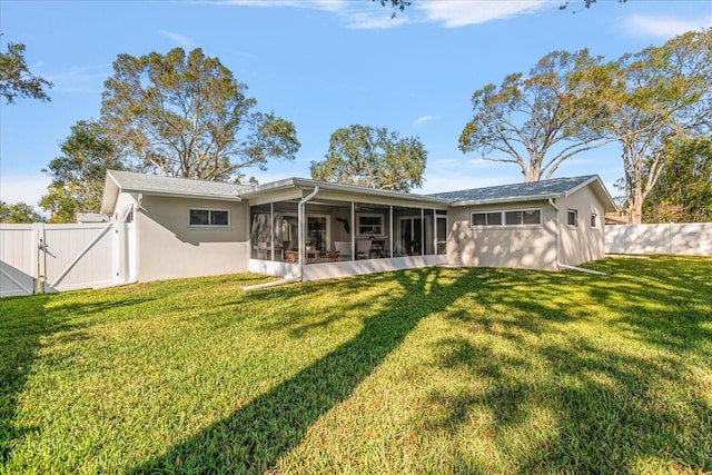 rear view of property featuring a yard and a sunroom