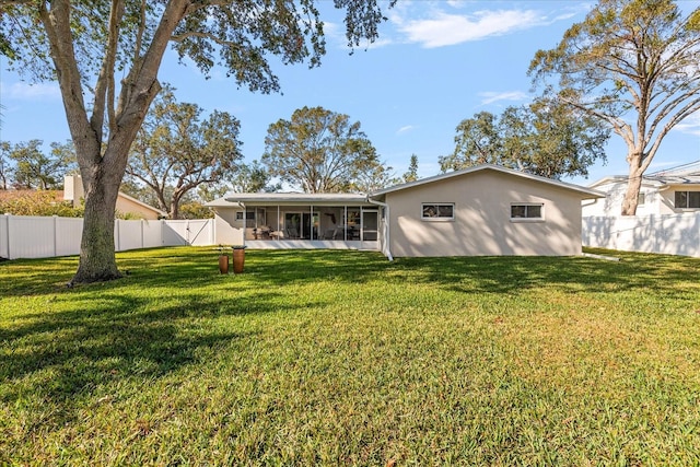 rear view of house with a sunroom and a yard