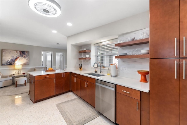 kitchen with stainless steel dishwasher, kitchen peninsula, backsplash, and sink