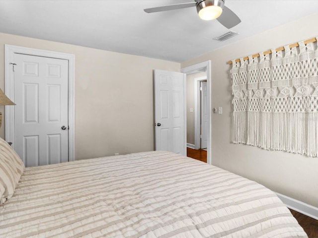 bedroom with dark hardwood / wood-style flooring and ceiling fan