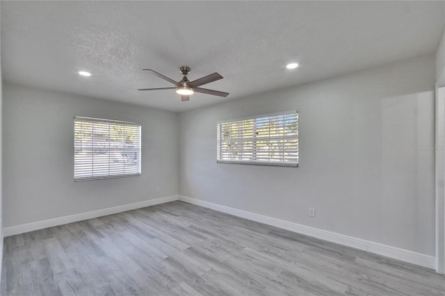 unfurnished room featuring ceiling fan, a textured ceiling, and light wood-type flooring