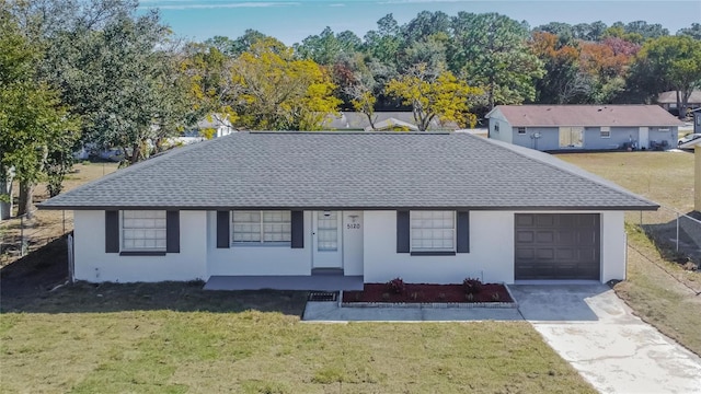 ranch-style home featuring a garage and a front lawn